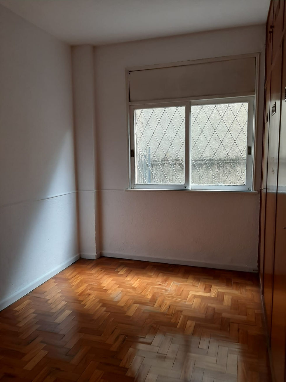 Miniatura: Quarto com piso de madeira, janela e armário embutido.
