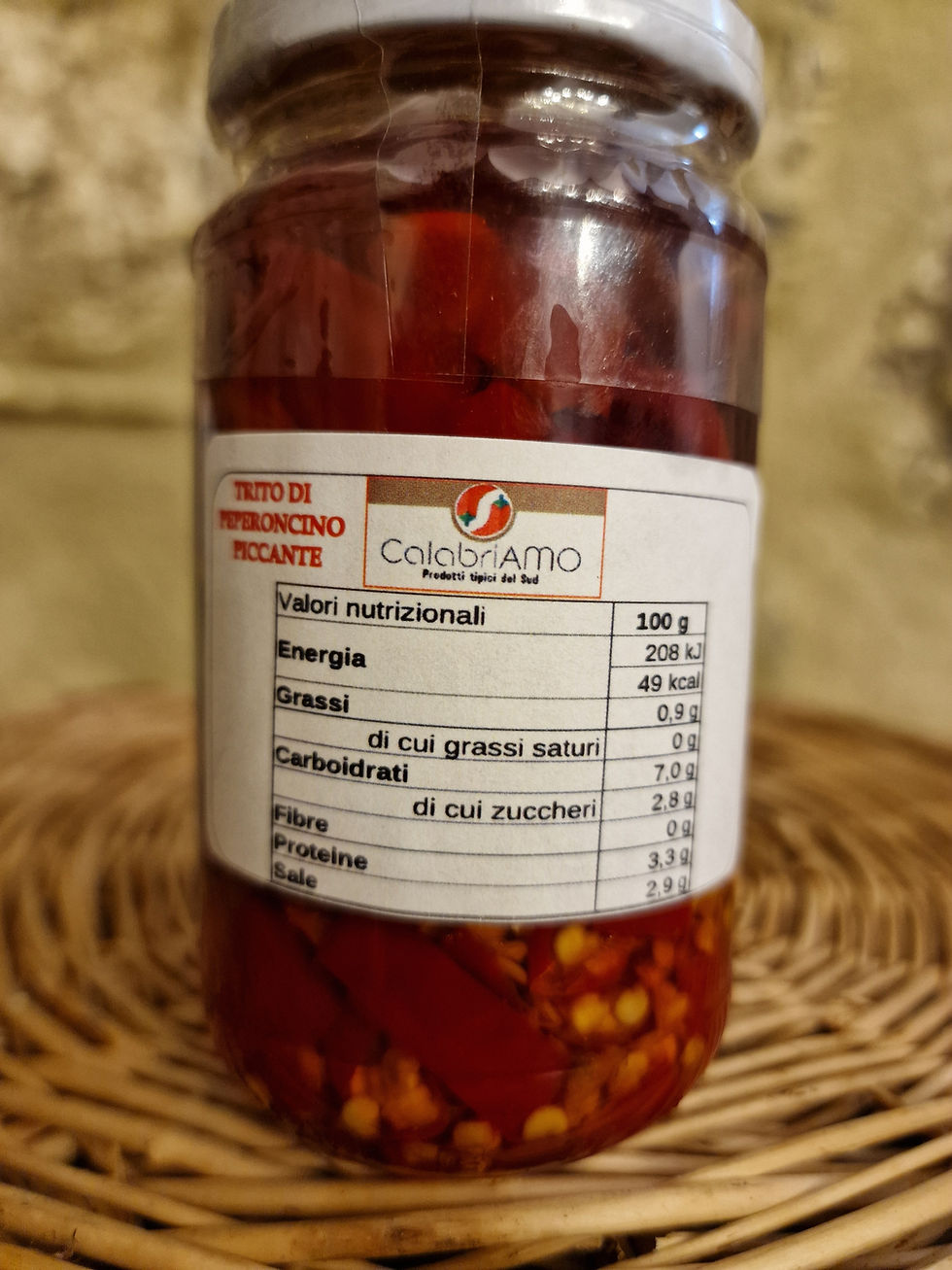 barattolo di trito di peperoncino piccante su sfondo in pietra