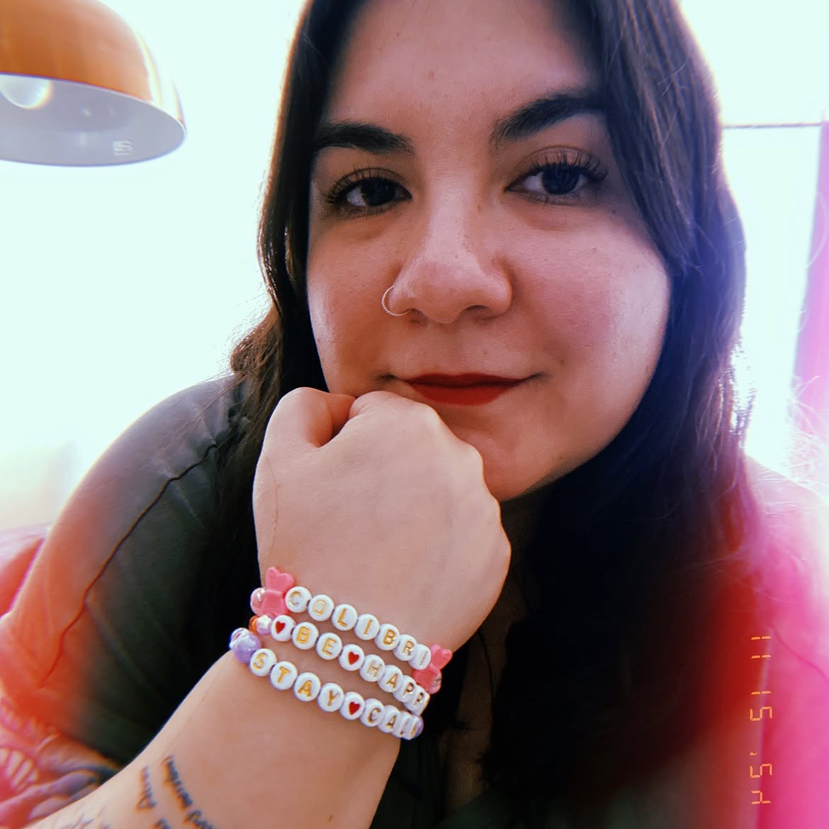 Mujer sonriendo con pulseras de cuentas de letras