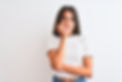 Young beautiful woman wearing casual t-shirt standing over isolated white background looki