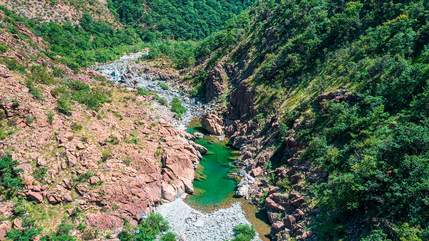 Veduta dall’alto del Gorzente e del Lago della Tartaruga, con acqua verde smeraldo tra rocce e boschi.