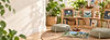 Cozy reading nook filled with children's picture books, a woven rug, cotton floor pillows and plants.