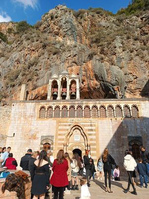 Visitors at Mar Antonios Qozhaya Monastery built into the steep mountainside of the Qadisha Valley