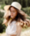 Woman wearing straw hat with long wavy hair.