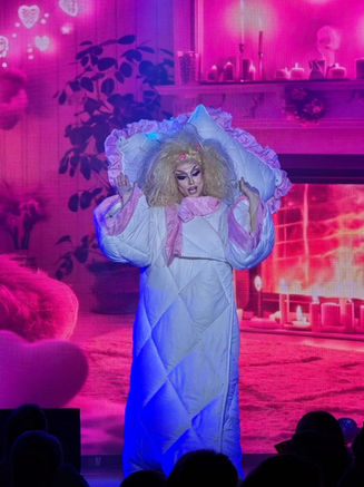 Comedy performer in bedtime costume on stage at Stardust Variety Show Cyprus with pink lighting