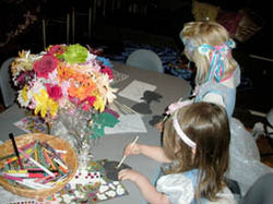 Children in fancy outfits doing crafts at a birthday party