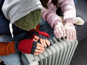 people placing hands on radiator