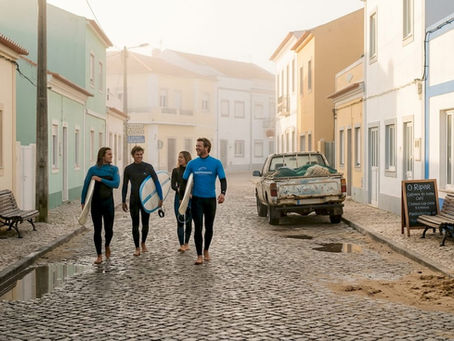 Surfers walk through Portugal village morning