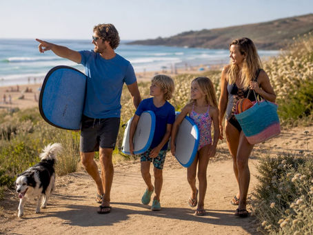 Family walking with surfboards on sunny beach