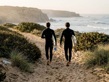 Local surfers walk to Portuguese beach at dawn
