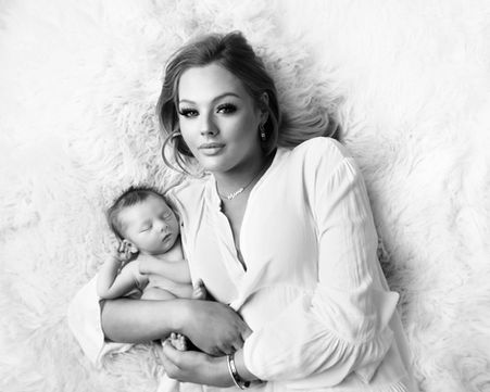 Newborn baby with his beautiful mum laying down cuddling on a flokati rug. photography near me newborn