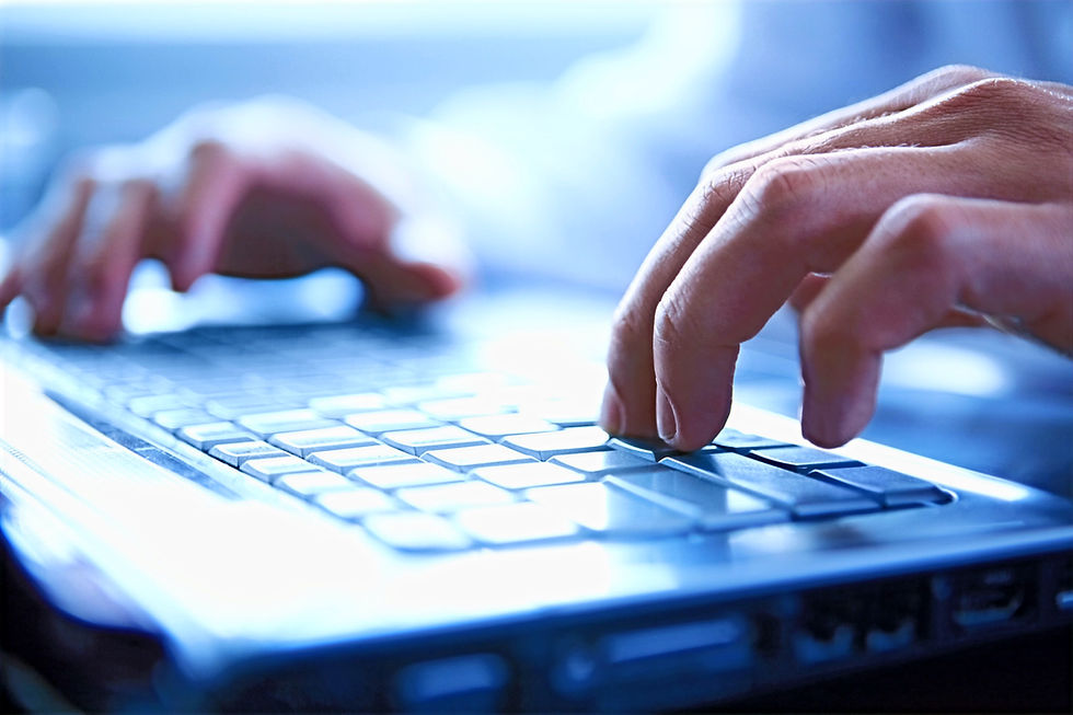 Hands typing on a laptop keyboard