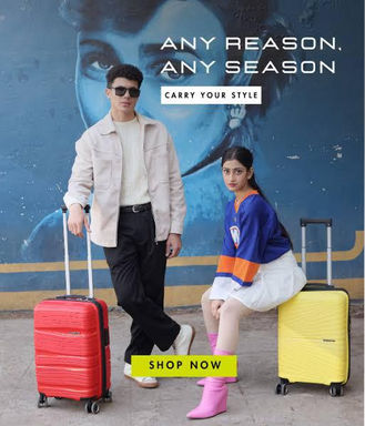 Couple with luggage pose with text: Any reason, any season. Shop now!