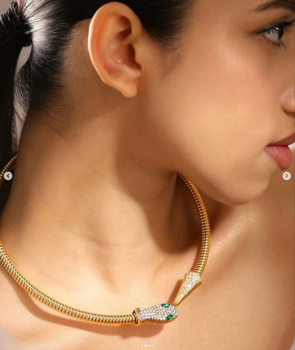 Woman wearing gold snake necklace, with green gem, DHE Studio.