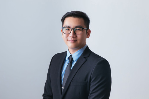 Man in blue collar shirt with black blazer standing, studio corporate photoshoot