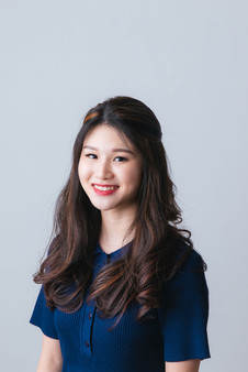 Lady with curls wearing blue dress, studio corporate photoshoot