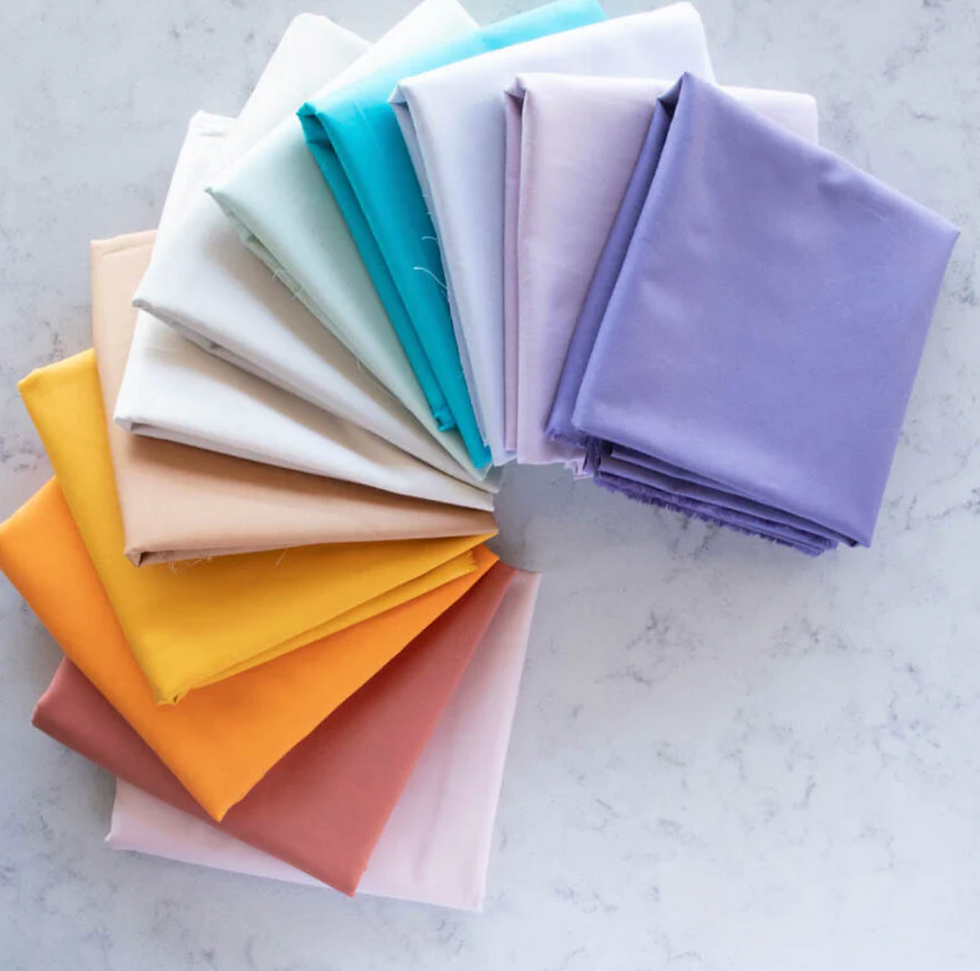 Assortment of folded fabric swatches in pastel colors