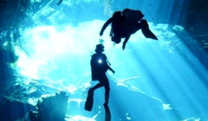 Dos buzos con linternas en el cenote de la Riviera Maya.