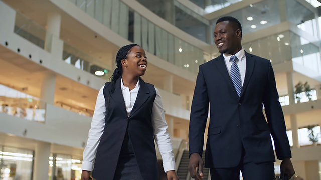 videoblocks-front-view-medium-shot-of-two-black-businesspeople-man-and-woman-walking-to-wo