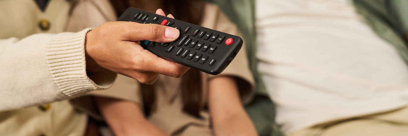 hand-holding-remote-control-against-blurred-background.jpg