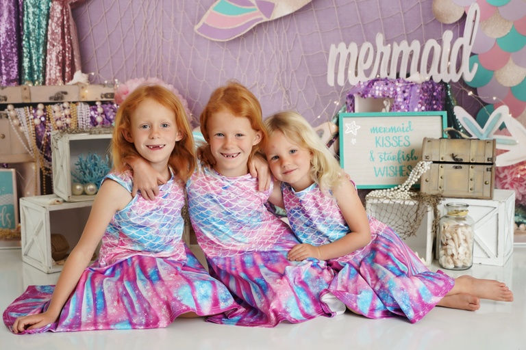 Child smiling in a seasonal themed backdrop during a Sacramento Monthly Special photo session