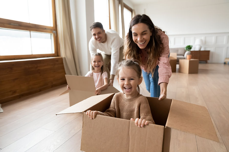 Happy parents playing with cute small kids daughters laughing on moving day, family tenant