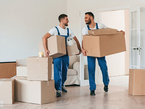 Front view, out of state movers holding stuff. Two moving service employees in a room..jpg
