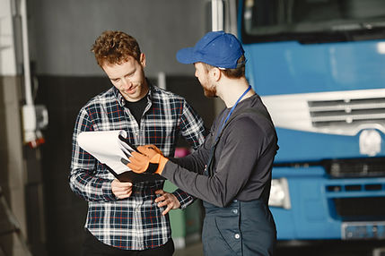 Happy customer and mover looking at a contract/invoice, next to a truck.