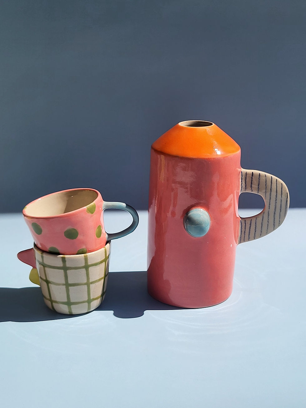 Vase au nez bleu sur fond bleu à côté de tasses