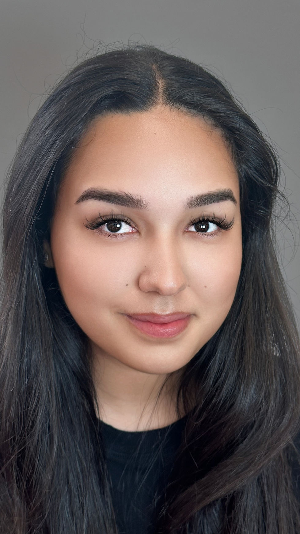 a close up of a woman 's face with a gray background