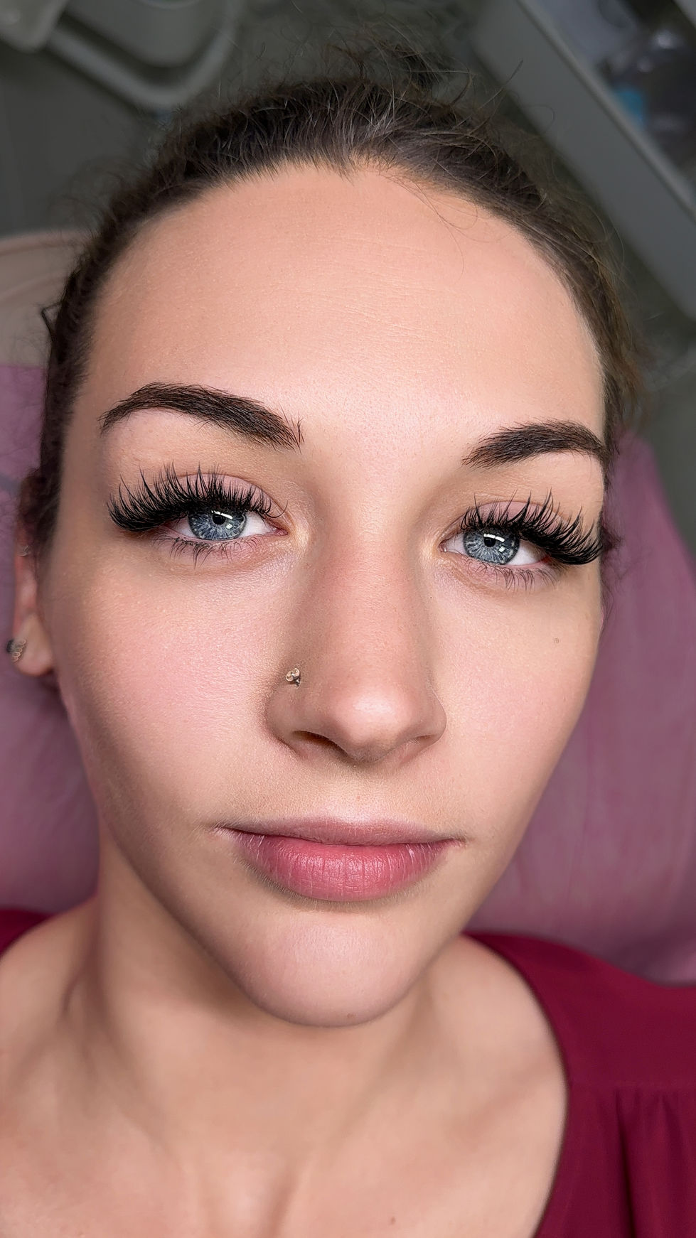 a close up of a woman 's face with a nose ring