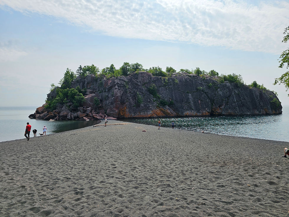 Black sand beach and large rocky island along Lake Superior in Silver Bay, Minnesota