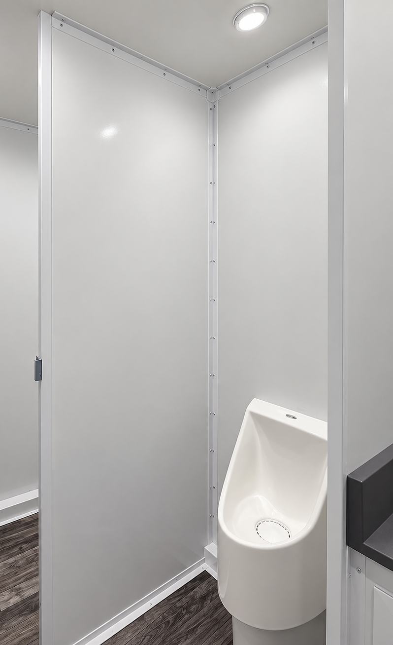 Men's side of the trailer with a urinal and a private toilet stall