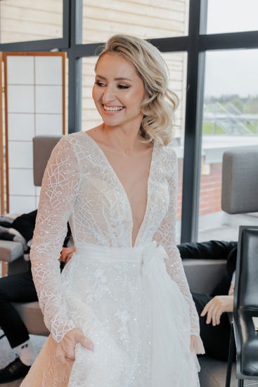 Candid wedding photography in the Cotswolds featuring a joyful bride laughing while getting ready for her ceremony.