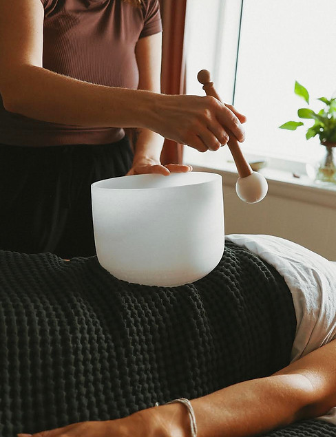 Quart crystal singing bowl being used in sound healing session