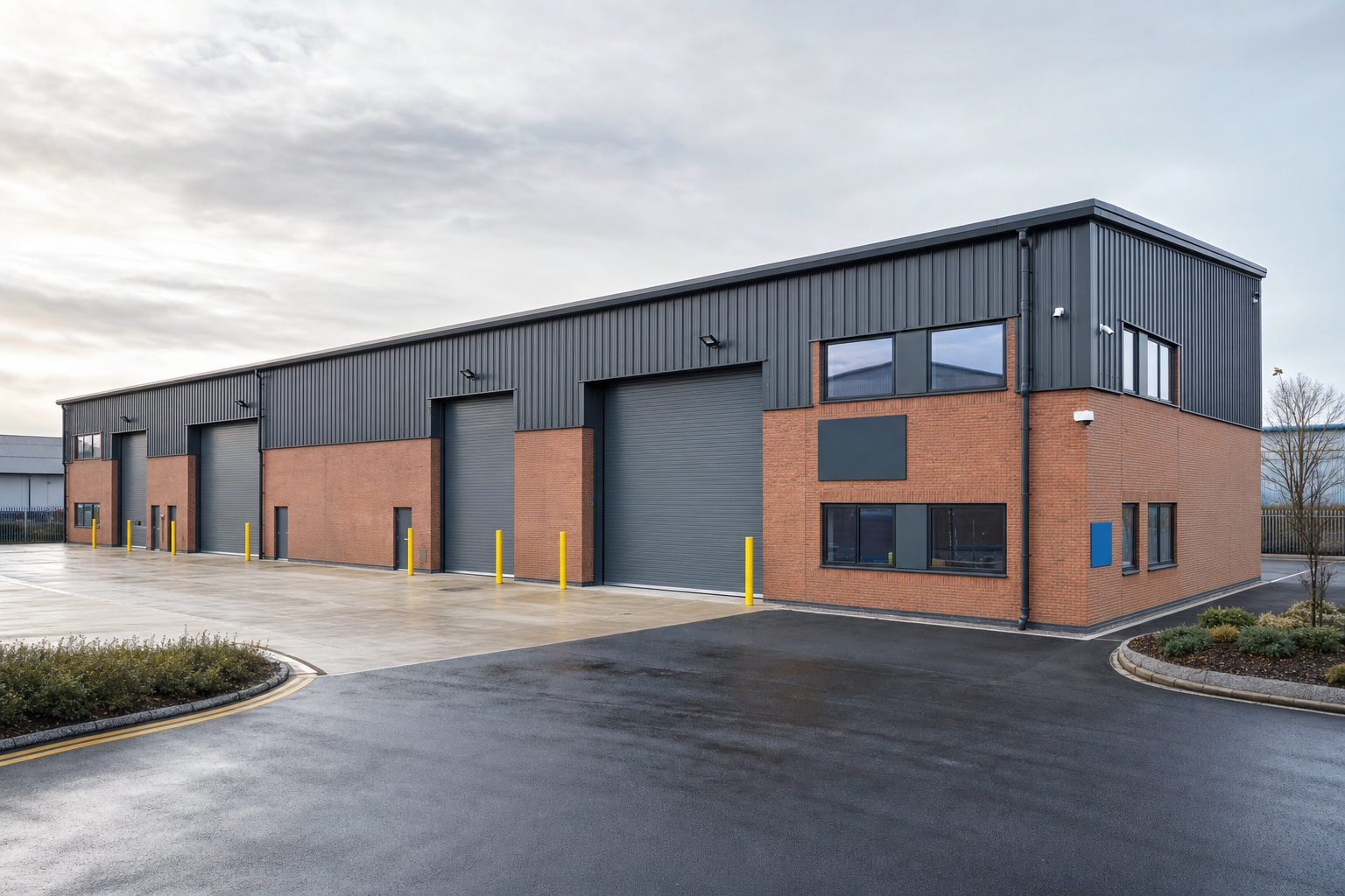 Modern industrial warehouse with brick and steel facade, featuring large roller doors and surrounded by a clean driveway.