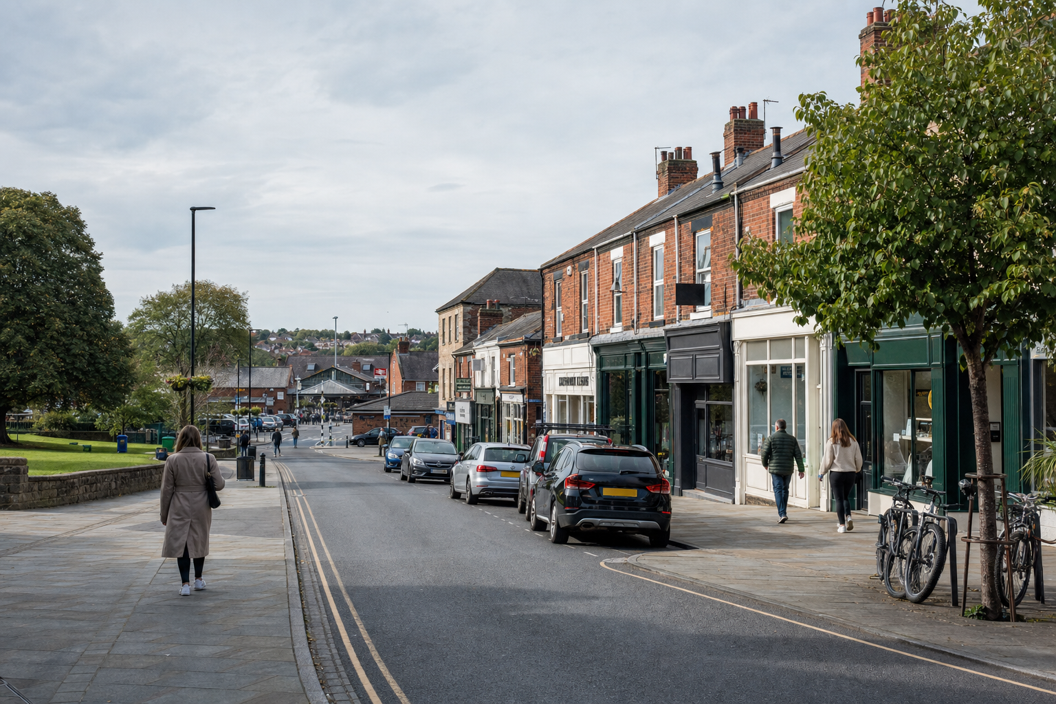 A quaint urban street with people walking, cars parked alongside, and a row of red-brick shops under a cloudy sky.