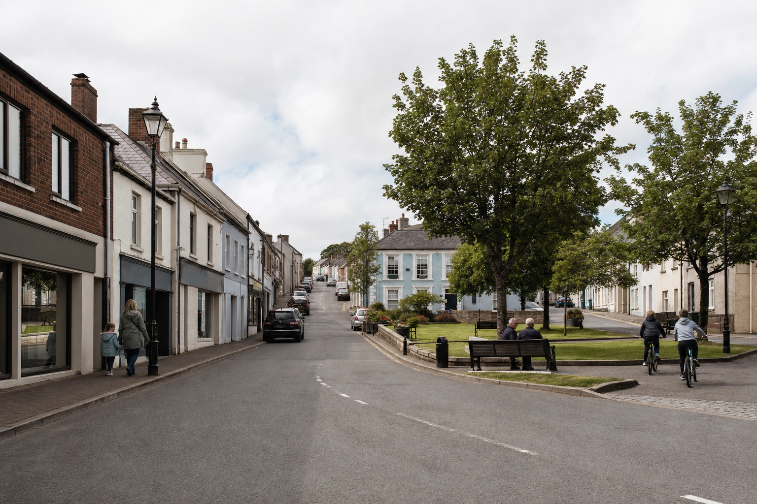 A quiet village street with terraced houses, a tree-lined square, and people walking and cycling.