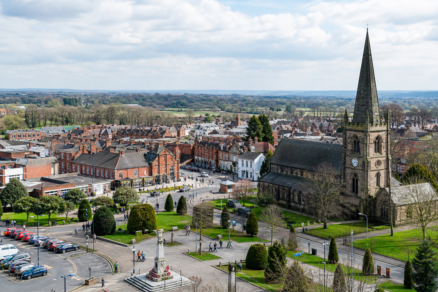 Aerial view of a historic town with a prominent church and surrounding buildings on a sunny day.