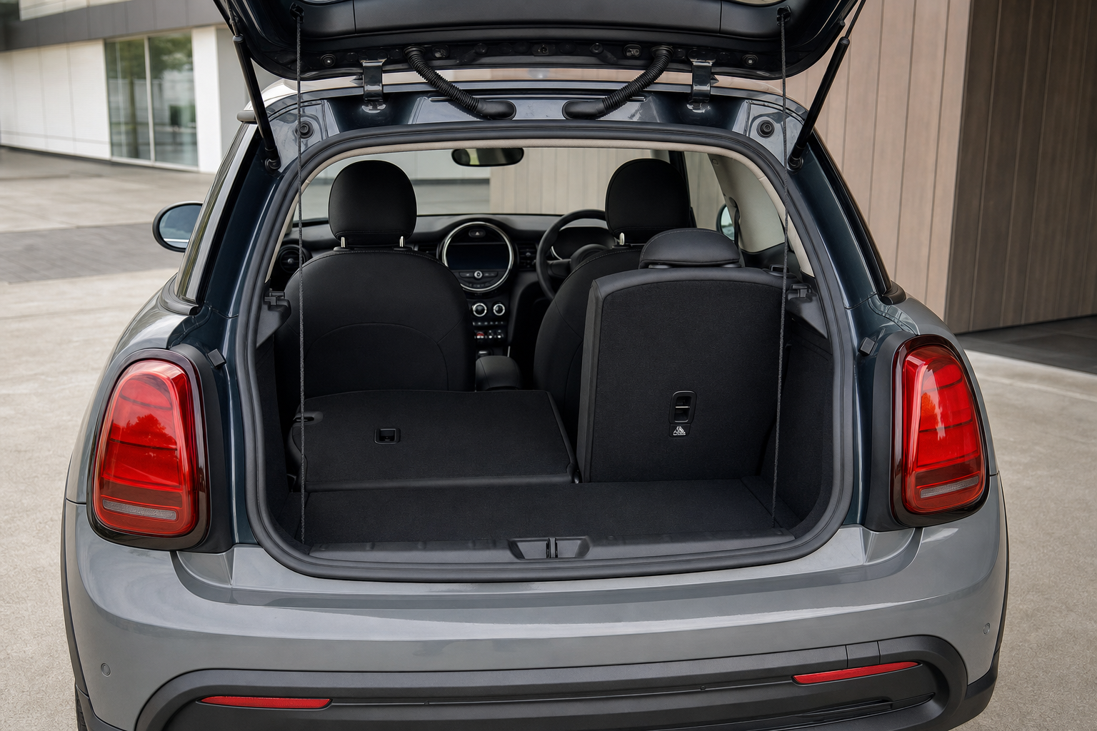 Open boot of a grey car showing the folded rear seats and interior dashboard.