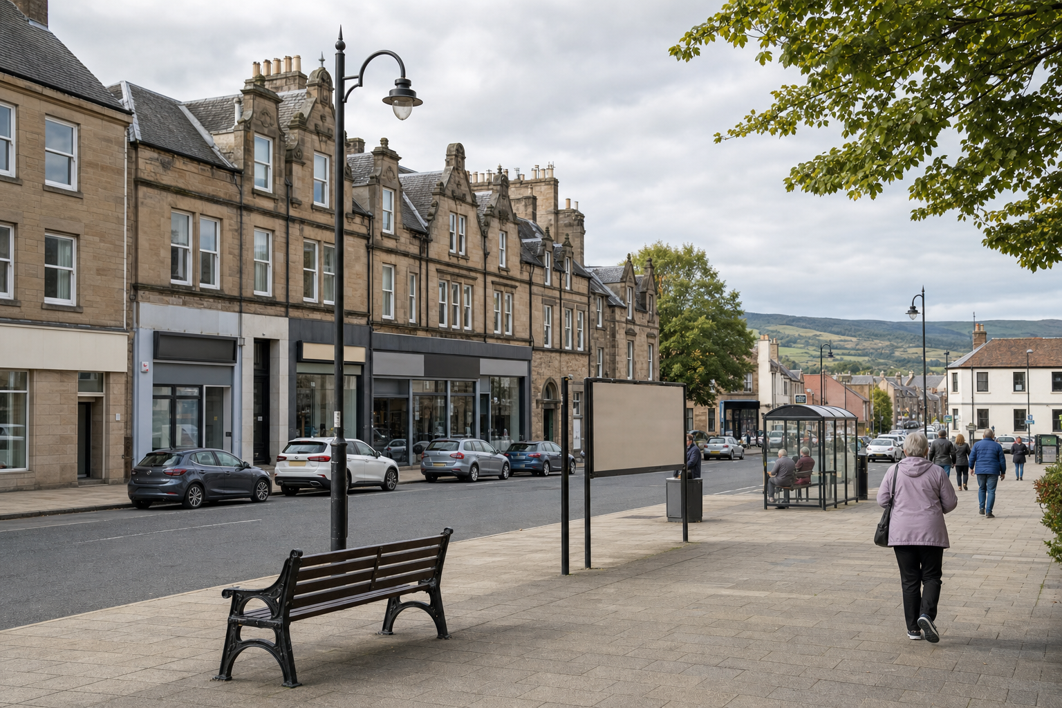 A quaint town street with historic buildings, parked cars, and people walking along the pavement under a cloudy sky.