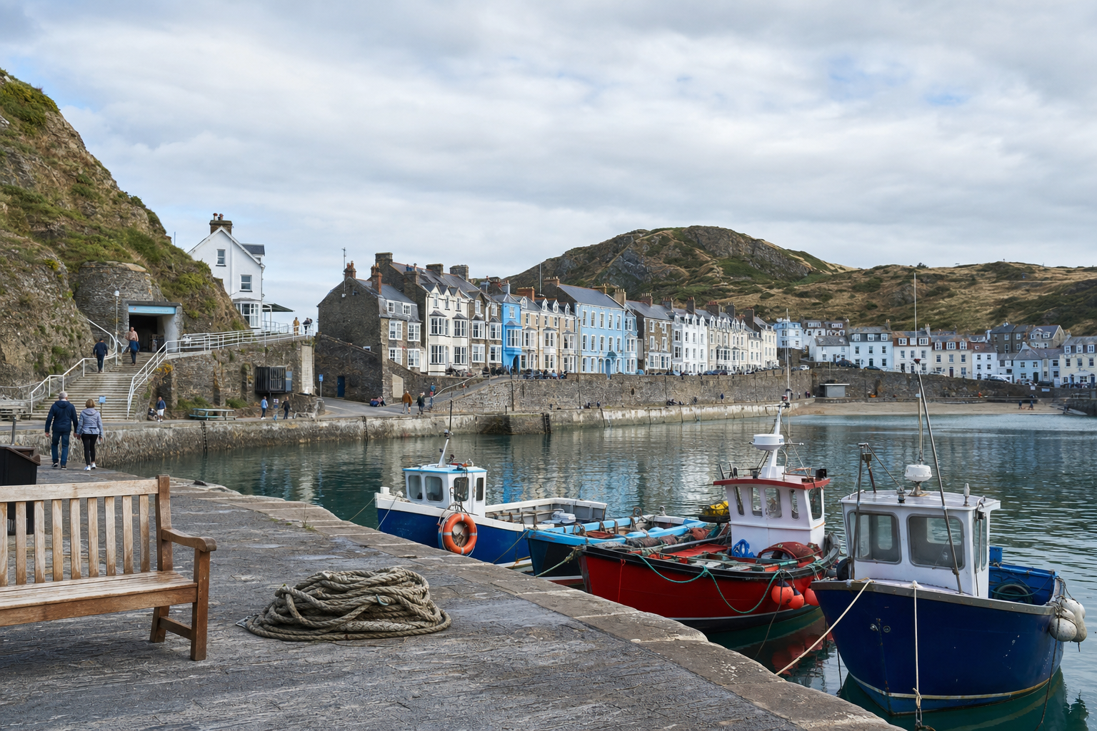 A picturesque harbour scene with colourful boats and rows of charming houses along the waterfront under a cloudy sky.