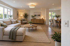 Modern open-plan living room with neutral tones, featuring a large sofa, wooden furniture, and plants for decor.