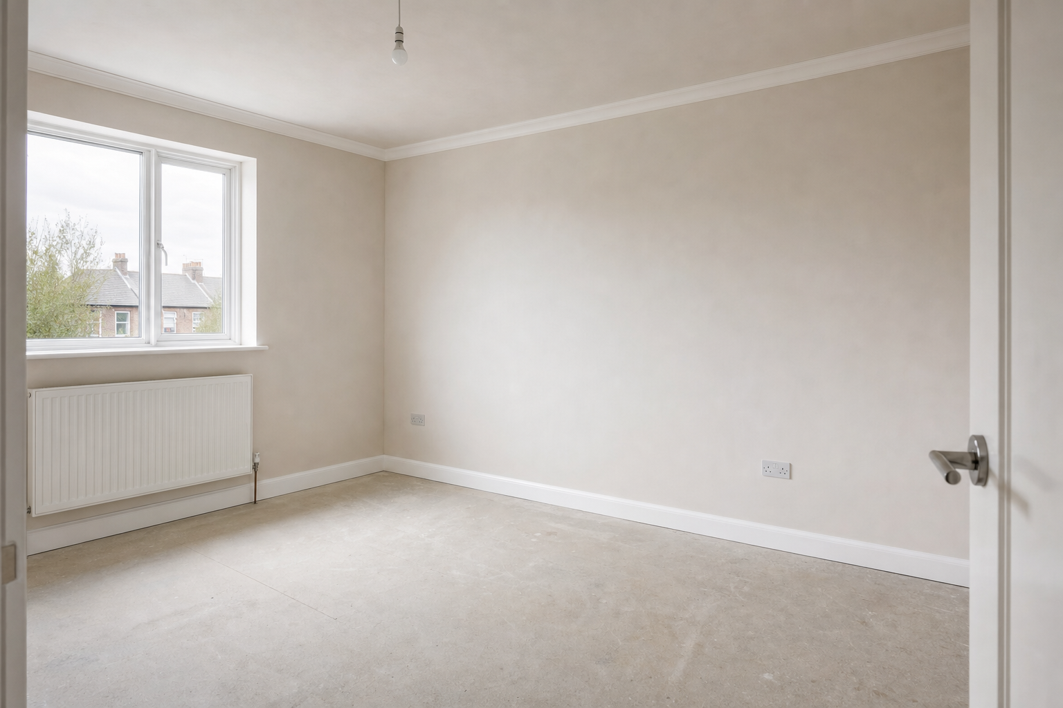 Empty room with beige walls, a large window, an exposed bulb, and a white radiator, viewed from an open doorway.