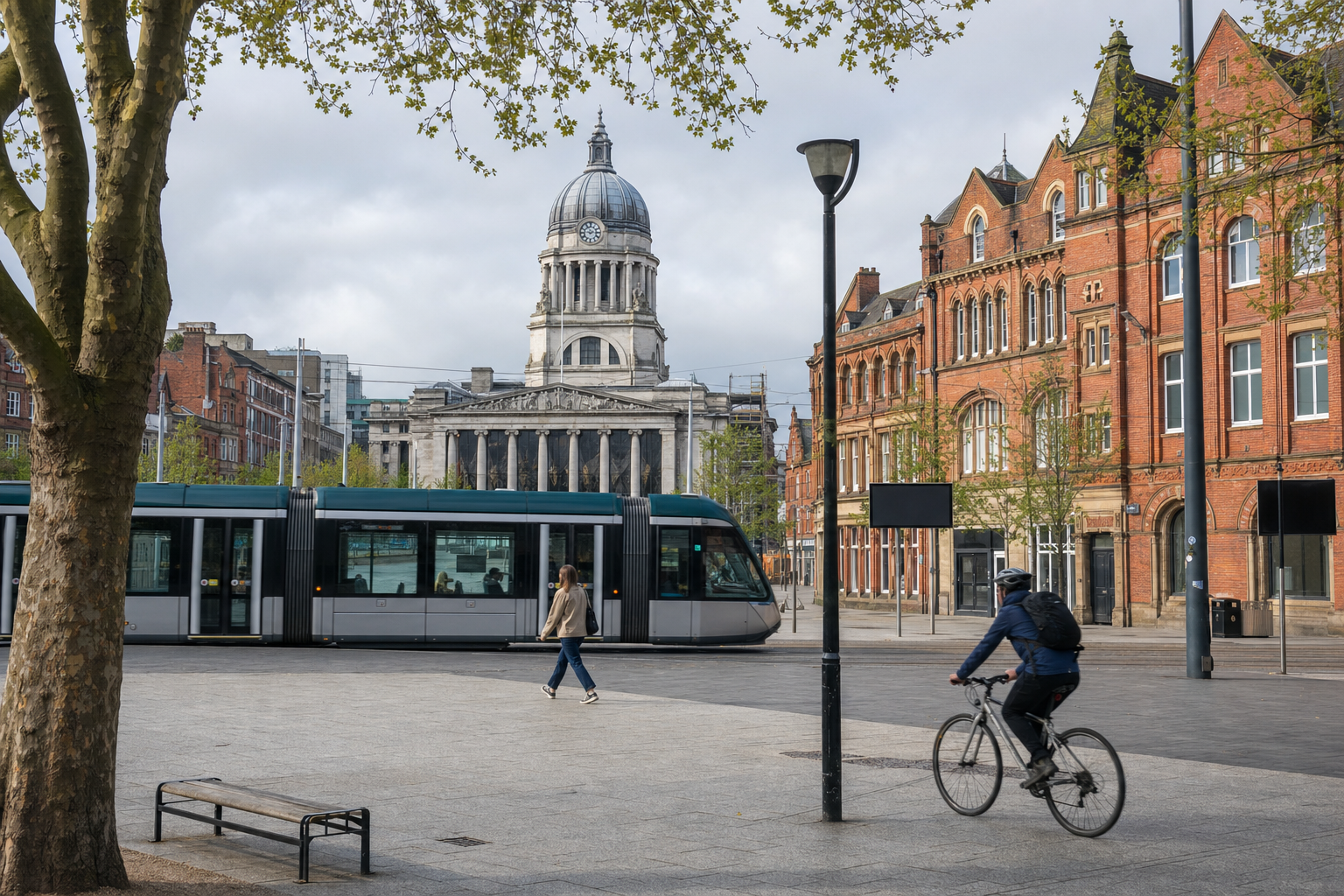 A tram passes in front of Nottingham Council House, with people walking and cycling in the city square.