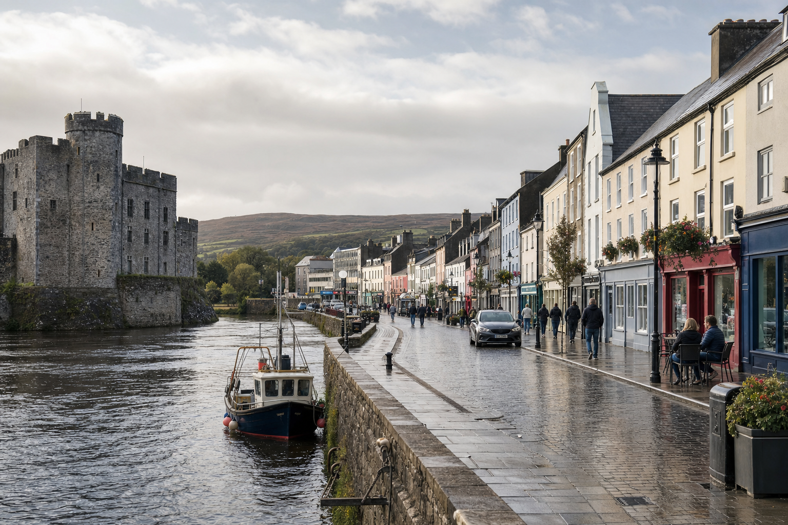 A riverside street with colourful buildings and a castle in the background on a cloudy day.