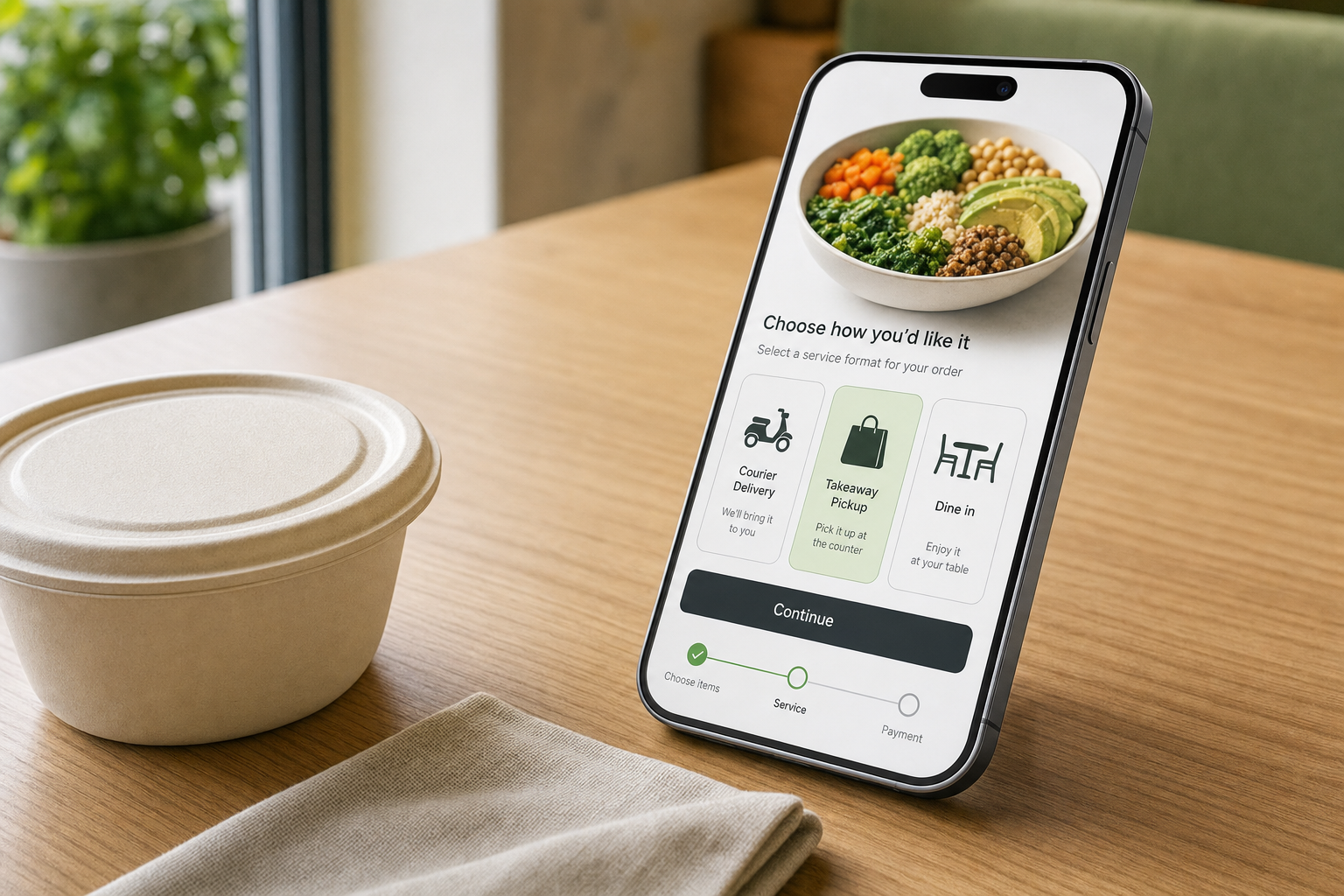 Smartphone displaying a food ordering app with delivery options next to a takeaway container on a wooden table.