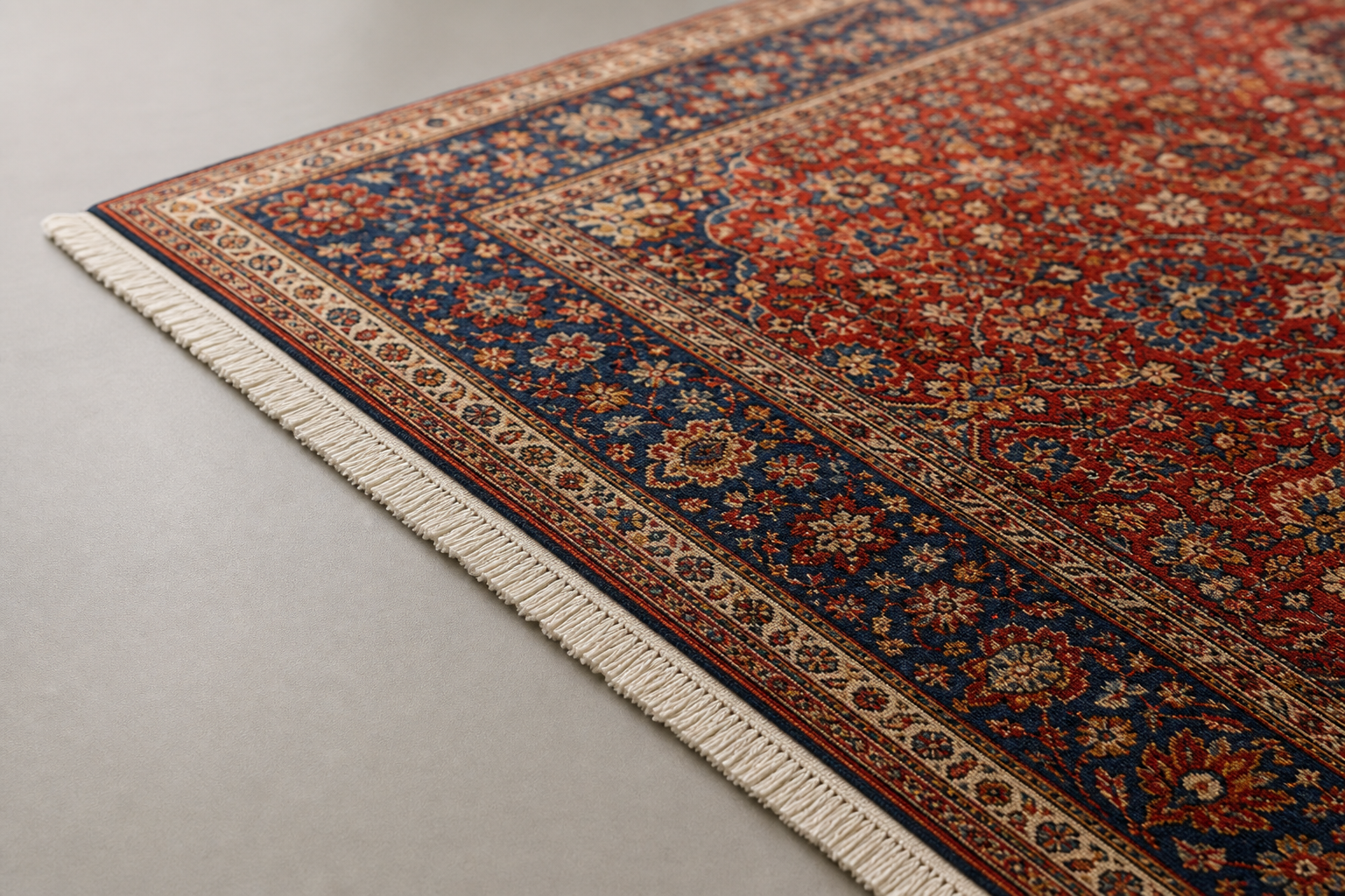 Ornate Persian rug with intricate red and blue floral patterns and a fringe on a light grey floor.