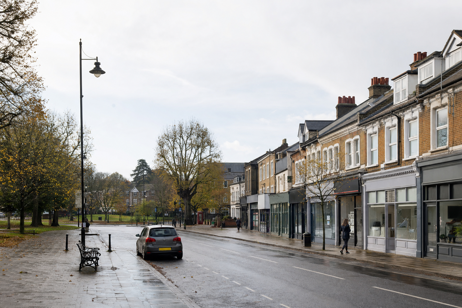 A quiet street scene features a row of shops, a parked car, and an overcast sky, with a park visible in the background.