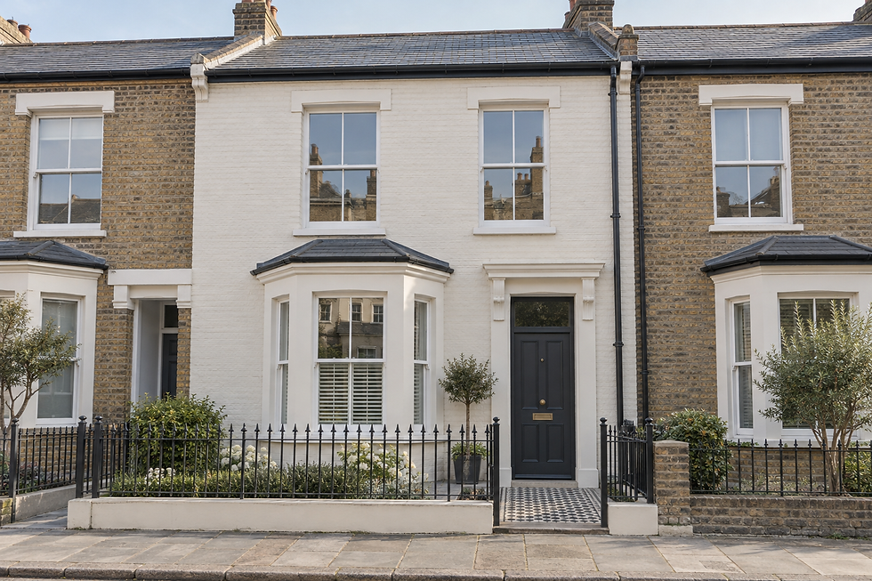 Terraced house with a white facade, black front door, bay windows, and a small garden enclosed by a black iron fence.